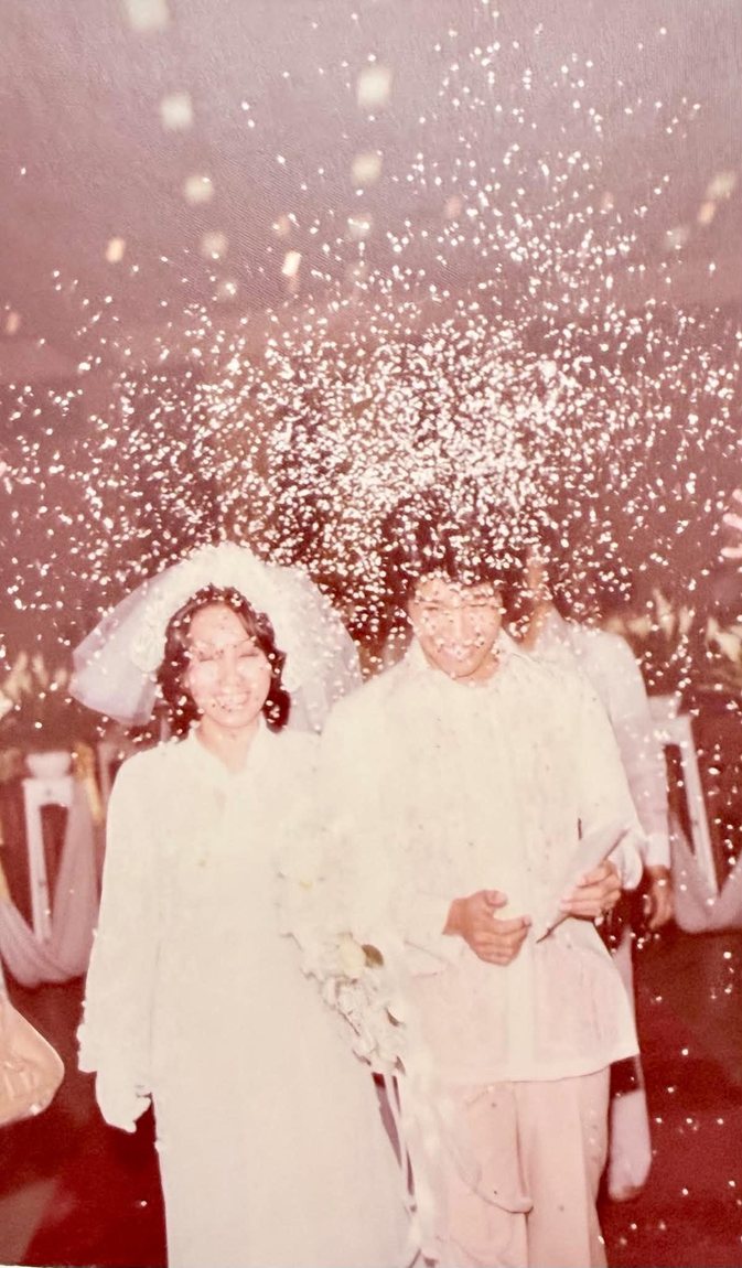 Eric and Star walking through a shower of rice on their wedding day